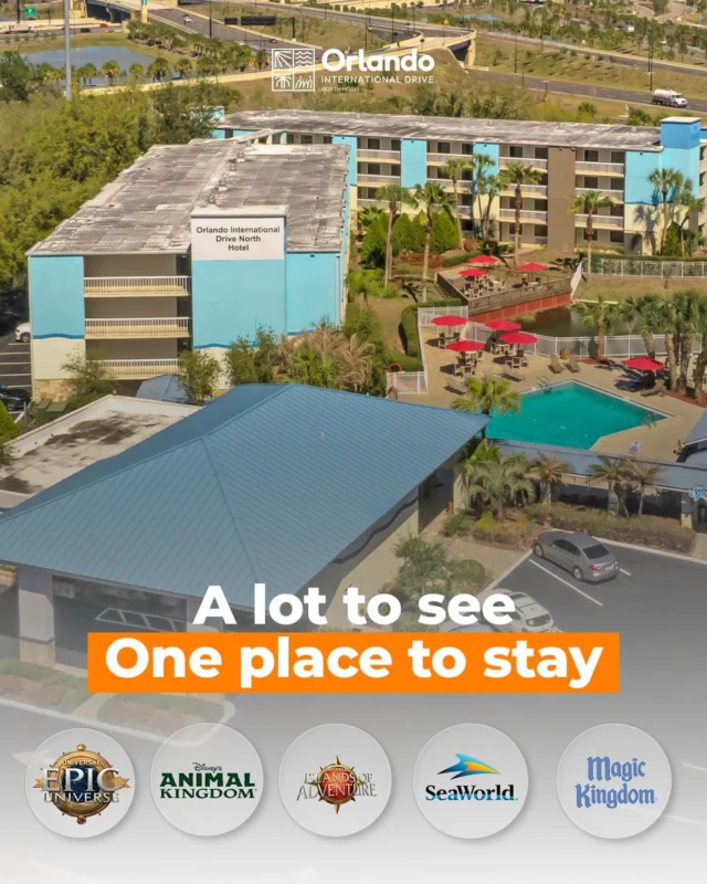 An aerial view of a hotel with a pool and parking lot.